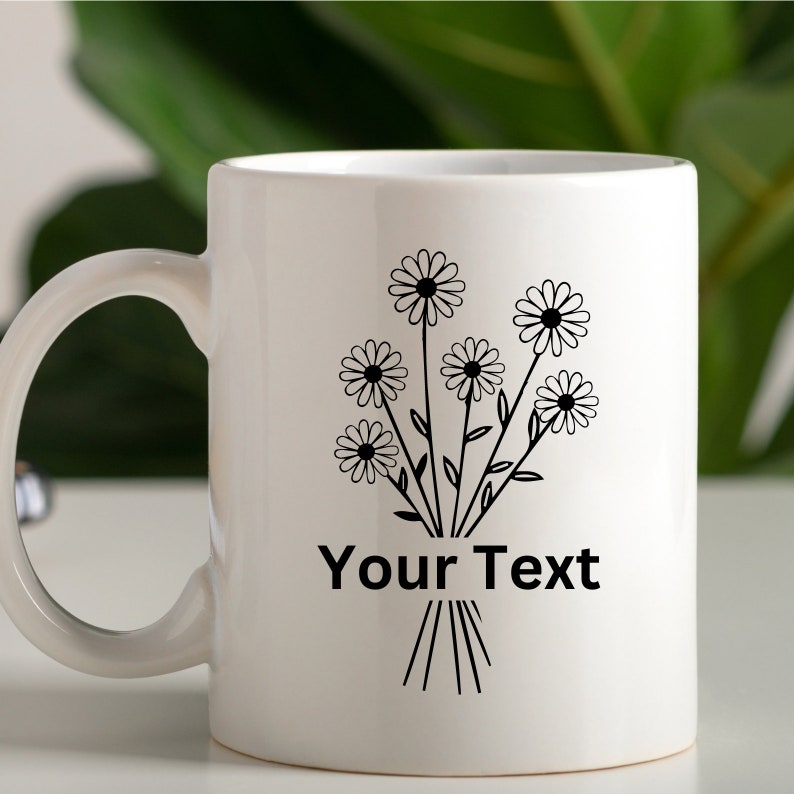 May include: White ceramic mug with a black outline of a bouquet of daisies and the text "Your Text".