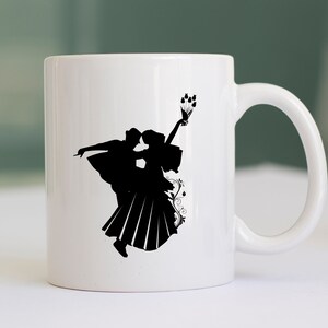 May include: White ceramic mug with a black silhouette of a couple dancing. The woman is holding a bouquet of flowers.