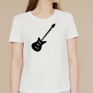 May include: White t-shirt featuring a black electric guitar graphic. The guitar design is a simple silhouette, with a body, neck, and headstock. The shirt is a classic crew neck style.