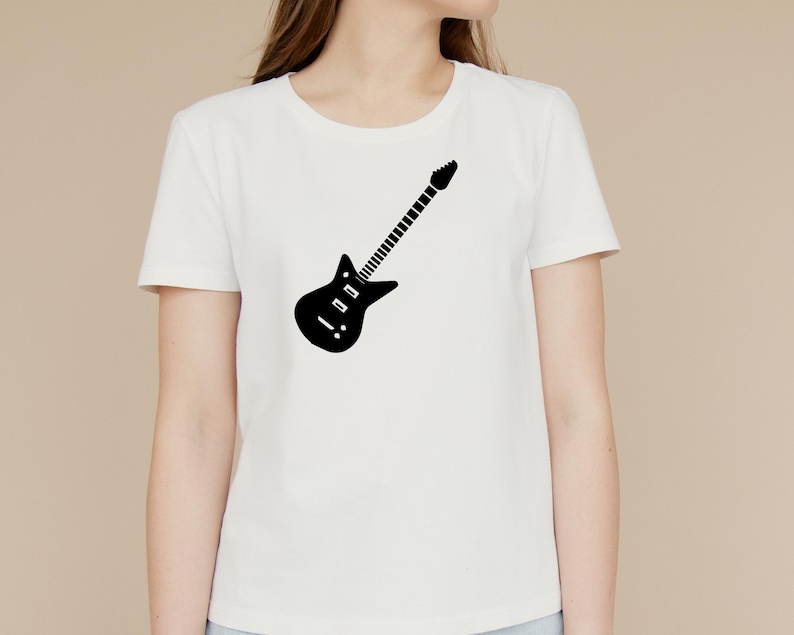 May include: White t-shirt featuring a black electric guitar graphic. The guitar design is a simple silhouette, with a body, neck, and headstock. The shirt is a classic crew neck style.