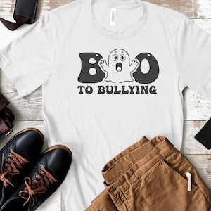 May include: White t-shirt with a black and white graphic of a ghost with the text "BOO TO BULLYING".