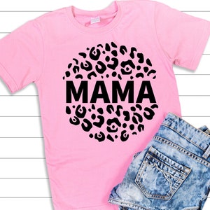 May include: Pink t-shirt with a black circle design featuring a leopard print and the word "MAMA" in the centre.