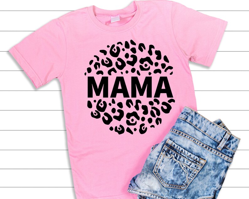 May include: Pink t-shirt with a black circle design featuring a leopard print and the word "MAMA" in the centre.