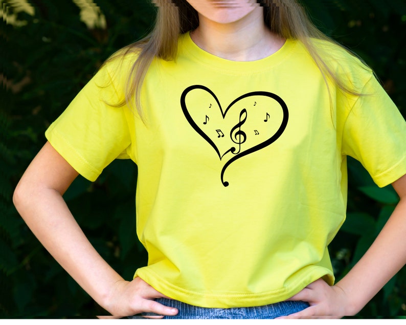 May include: A yellow t-shirt with a black heart design featuring a treble clef and musical notes.
