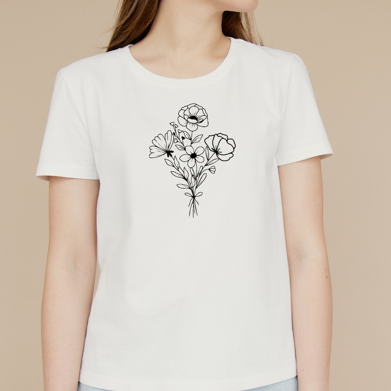May include: White t-shirt with a black line drawing of a bouquet of flowers.
