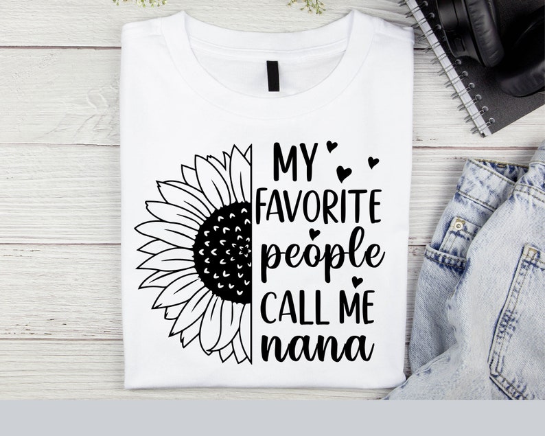 May include: White t-shirt with a black sunflower graphic and the text "My favorite people call me nana" with small hearts.