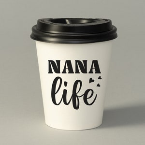 May include: White to-go coffee cup with a black lid. The cup has the text "NANA life" printed on it in black.