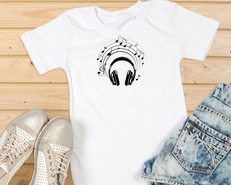 May include: White t-shirt with a black graphic of headphones and musical notes.