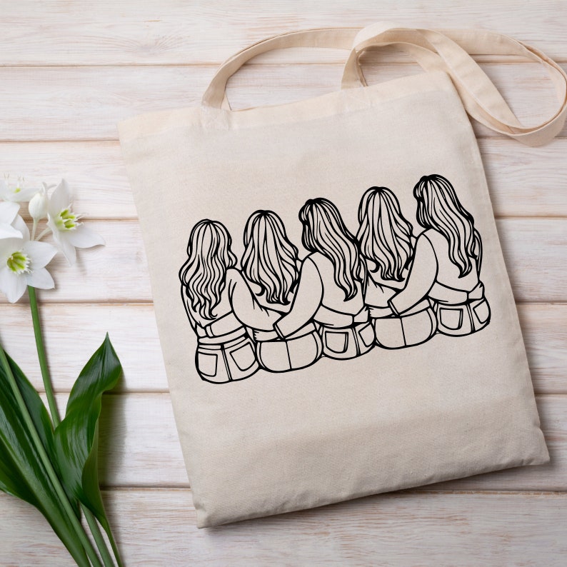 May include: A tote bag with a black and white line drawing of four women with long hair, sitting back to back with their arms around each other. The women are wearing jeans.