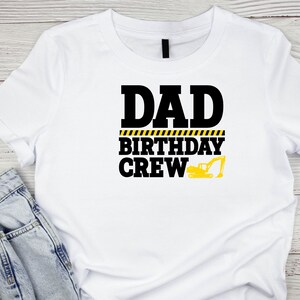 May include: White t-shirt with black text that reads "Dad Birthday Crew" with a yellow and black caution tape design and a yellow excavator graphic.