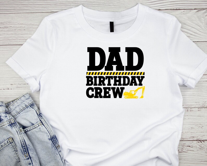 May include: White t-shirt with black text that reads "Dad Birthday Crew" with a yellow and black caution tape design and a yellow excavator graphic.