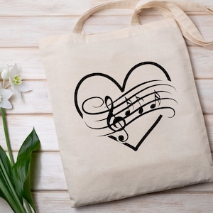 May include: A white canvas tote bag with a black heart design featuring musical notes and a treble clef. The heart is outlined in black and the musical notes are stylized.