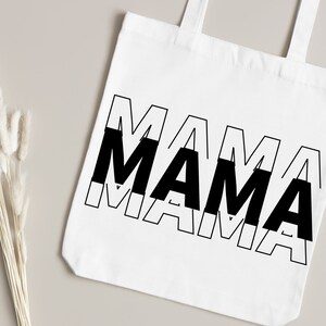 May include: White tote bag with black text that reads "MAMA" in a layered, overlapping design.