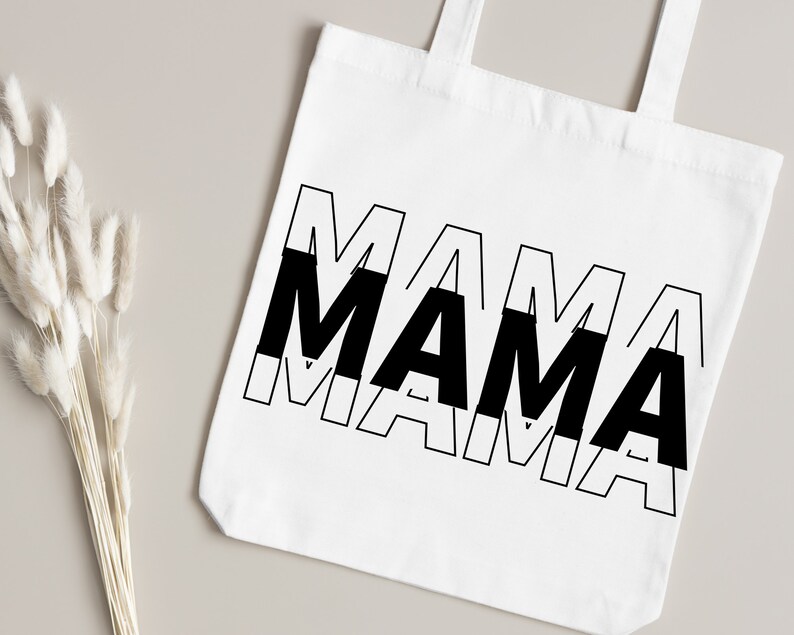 May include: White tote bag with black text that reads "MAMA" in a layered, overlapping design.