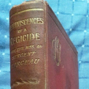 May include: A brown leather-bound book with gold lettering on the spine. The title is "Reminiscences of a Regicide from the MSS of Sergeant  Marceau" and the author is "W.C.M. Simpson".