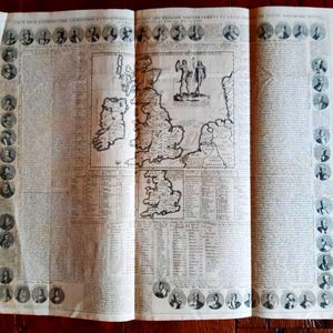 May include: An antique map of the British Isles, featuring detailed cartography and text. The map is surrounded by portraits of historical figures. The paper has a vintage, aged appearance, with visible folds and creases, suggesting its age and history.