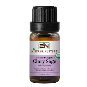 May include: A small amber glass bottle of Nirvana Nurture Clary Sage essential oil. The label is purple and white with the text "Certified Organic Clary Sage" and "1/3 FL OZ. (10mL)". The bottle has a black cap.