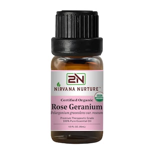 Puede incluir: Una pequeña botella de vidrio ámbar de aceite esencial de Nirvana Nurture Rose Geranium. La etiqueta es rosa y blanca, con el texto "Rose Geranium" y "1/3 FL OZ. (10ml)". La botella tiene una tapa negra.