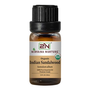 May include: A small amber glass bottle of Nirvana Nurture organic Indian Sandalwood essential oil. The label includes the text "100% Pure Essential Oil" and "1/3 FL OZ. (10mL)". The bottle has a black cap.