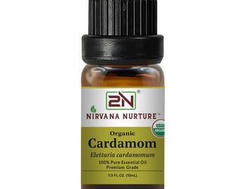 May include: A small glass bottle of organic cardamom essential oil. The bottle has a black cap and a yellow label with the text "Nirvana Nurture" and "Organic Cardamom". The bottle contains 10 ml of oil.