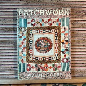 May include: A book titled "PATCHWORK" with a colourful quilt design on the cover. The cover features a central floral motif within a square frame, surrounded by various patchwork patterns. The author's name, AVERIL COLBY, is printed at the bottom.