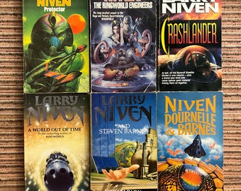 May include: Six vintage science fiction books by Larry Niven, featuring colorful covers with futuristic illustrations. Titles include "Protector," "The Ringworld Engineers," and "Crashlander." The books are arranged on a wooden surface.