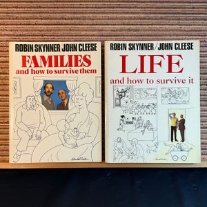May include: Two paperback books with illustrated covers. The book on the left is titled "Families and how to survive them". The book on the right is titled "Life and how to survive it". Both books are by Robin Skinner and John Cleese.
