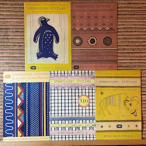May include: A collection of vintage embroidery stitch books. The covers feature illustrations of a penguin, geometric patterns, and a ram. Each book has the title "Embroidery Stitches" and the "NDS" logo.