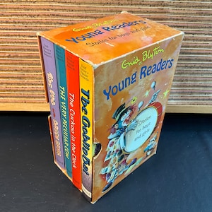May include: A set of three Enid Blyton Young Readers books featuring the titles "The Gobly-Bub", "The Cuckoo in the Clock", and "The Very Peculiar Cow". The books are in a slipcase with a colourful illustration of a clown playing a drum.