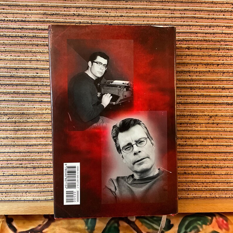 May include: A book cover with a red background featuring two black and white portraits. One shows a person at a typewriter, the other a close-up of a person wearing glasses. The book's spine includes the ISBN.