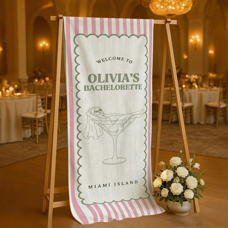 May include: A welcome banner for Olivia's bachelorette party, featuring a martini glass illustration with a woman relaxing inside. The banner has a pink and white striped border and the words "Welcome to Olivia's Bachelorette" and "Miami Island".