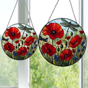 May include: Two round stained glass window hangings featuring red poppies and dragonflies. The larger hanging is 12 inches in diameter and the smaller hanging is 8 inches in diameter.