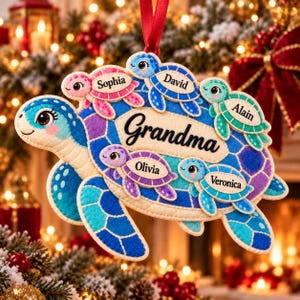 May include: A felt sea turtle ornament featuring a large blue and purple shell with the word Grandma printed in black. Five smaller colorful baby turtles are attached to the shell, each labeled with the names Sophia, David, Alain, Olivia, and Veronica.