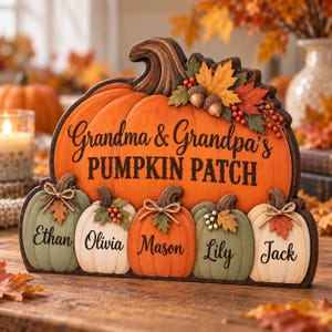 May include: A decorative wooden sign shaped like a large orange pumpkin with the text Grandma & Grandpa's PUMPKIN PATCH. Below are five smaller pumpkins in shades of green, white, and orange, each personalized with the names Ethan, Olivia, Mason, Lily, and Jack.