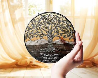Könnte beinhalten: Ein runder Buntglas-Sonnenfänger mit einem detaillierten Baum mit silbernen Blättern und einem strukturierten Stamm. Der Hintergrund zeigt Berge in Gold- und Brauntönen. Der Text lautet 25th Anniversary, Nick & Mary, 03-29-2000.