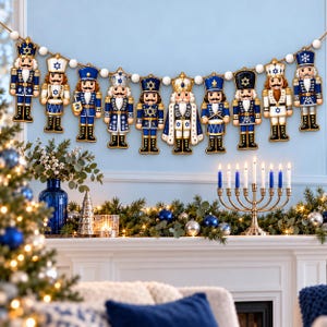 May include: A decorative garland featuring ten wooden nutcracker figures in blue and white uniforms, each adorned with Star of David motifs, strung together on a cord with white wooden beads between each figure for holiday display.