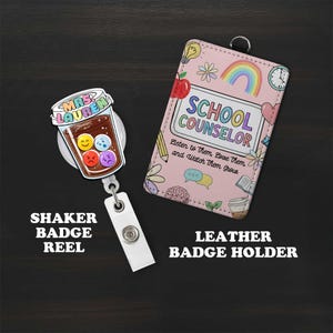 May include: A shaker badge reel with a coffee cup design and a leather badge holder. The badge reel features a cup with colorful emoji faces. The badge holder is pink with a rainbow and the words "School Counselor".