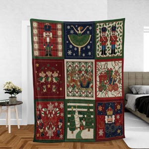 May include: A Christmas-themed throw blanket with a patchwork design. The blanket features squares with images of nutcrackers, a ballerina, mice, a reindeer-pulled sleigh, gifts, candy canes, Christmas trees, and snowflakes. The blanket is trimmed with a green border.