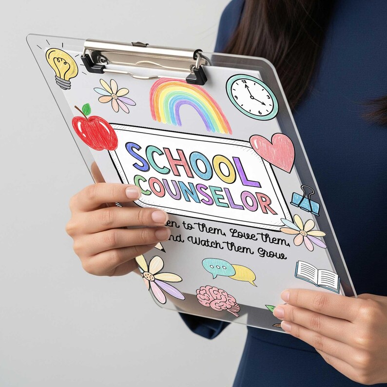 May include: Clear clipboard with a metal clip, featuring colorful illustrations of a rainbow, apple, flowers, and a clock. The text "SCHOOL COUNSELOR" is prominently displayed, along with the phrase "Listen to them, Love them, and Watch them Grow."