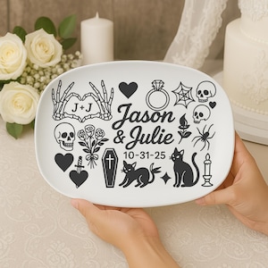 Może przedstawiać: Biały owalny talerz z czarnymi ilustracjami w stylu gotyckim, w tym czaszkami, pajęczyną i kotami. Talerz zawiera imiona "Jason & Julie" oraz datę "10-31-25".