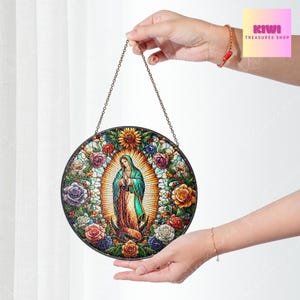 May include: A round stained glass window hanging from a chain. The window features a colourful image of the Virgin Mary surrounded by flowers.