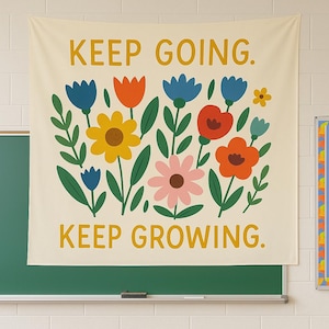 Puede incluir: Un tapiz de pared color crema con las palabras "KEEP GOING. KEEP GROWING." en amarillo. El tapiz presenta un diseño floral colorido con flores azules, naranjas, amarillas, rosas y rojas con hojas verdes.