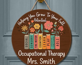 May include: A round wooden sign with the text "Helping You Grow To Your Full Potential" and "Occupational Therapy Mrs. Smith". The sign features colorful flowers growing from books labeled with therapy-related terms.