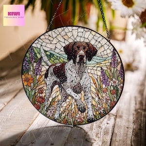 May include: A stained glass suncatcher featuring a brown and white German Shorthaired Pointer dog walking through a field of flowers. The suncatcher is round and has a mosaic design.