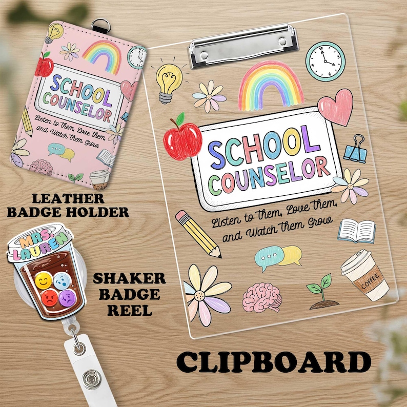 May include: A pink leather badge holder, a clear clipboard, and a shaker badge reel. The badge holder and clipboard feature the text "SCHOOL COUNSELOR" with colorful illustrations of an apple, rainbow, and pencil. The shaker badge reel has a coffee cup design.