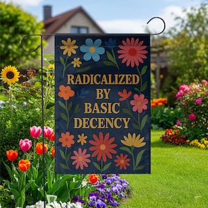 Könnte beinhalten: Eine marineblaue Gartenflagge mit dem Text "RADICALIZED BY BASIC DECENCY" in goldfarbenen Buchstaben, umgeben von bunten Blumenillustrationen. Die Flagge wird im Freien in einem Garten gezeigt.