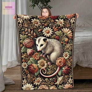 May include: A black and white opossum with a white face and pink nose is nestled in a floral pattern. The opossum is surrounded by pink, white, and yellow flowers. The background is a dark brown with a floral pattern.