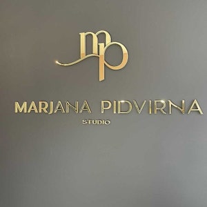 May include: Gold logo with the letters "MP" intertwined and the text "MARJANA PIDVIRNA STUDIO" below.