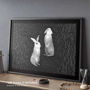 May include: A rectangular wall art print featuring two rabbits in shades of gray and white against a dark background filled with intricate white line patterns of foliage. The artwork includes the text "NO frame is included. Artwork &copy; Ida Rezaee."