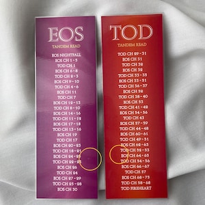 May include: Two pink and red bookmark cards with the words "EOS" and "TOD" printed in white. The cards list chapter numbers for the books "EOS" and "TOD" with the words "TANDEM READ" printed at the top of each card.